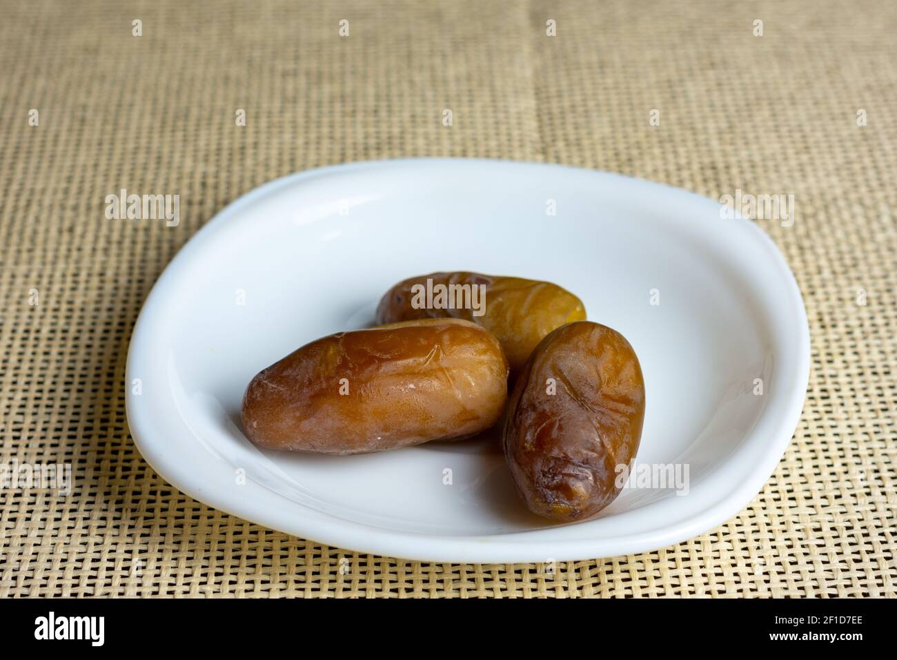 Primo piano delle date reali algerine su un piatto bianco, concetto Ramadan Foto Stock