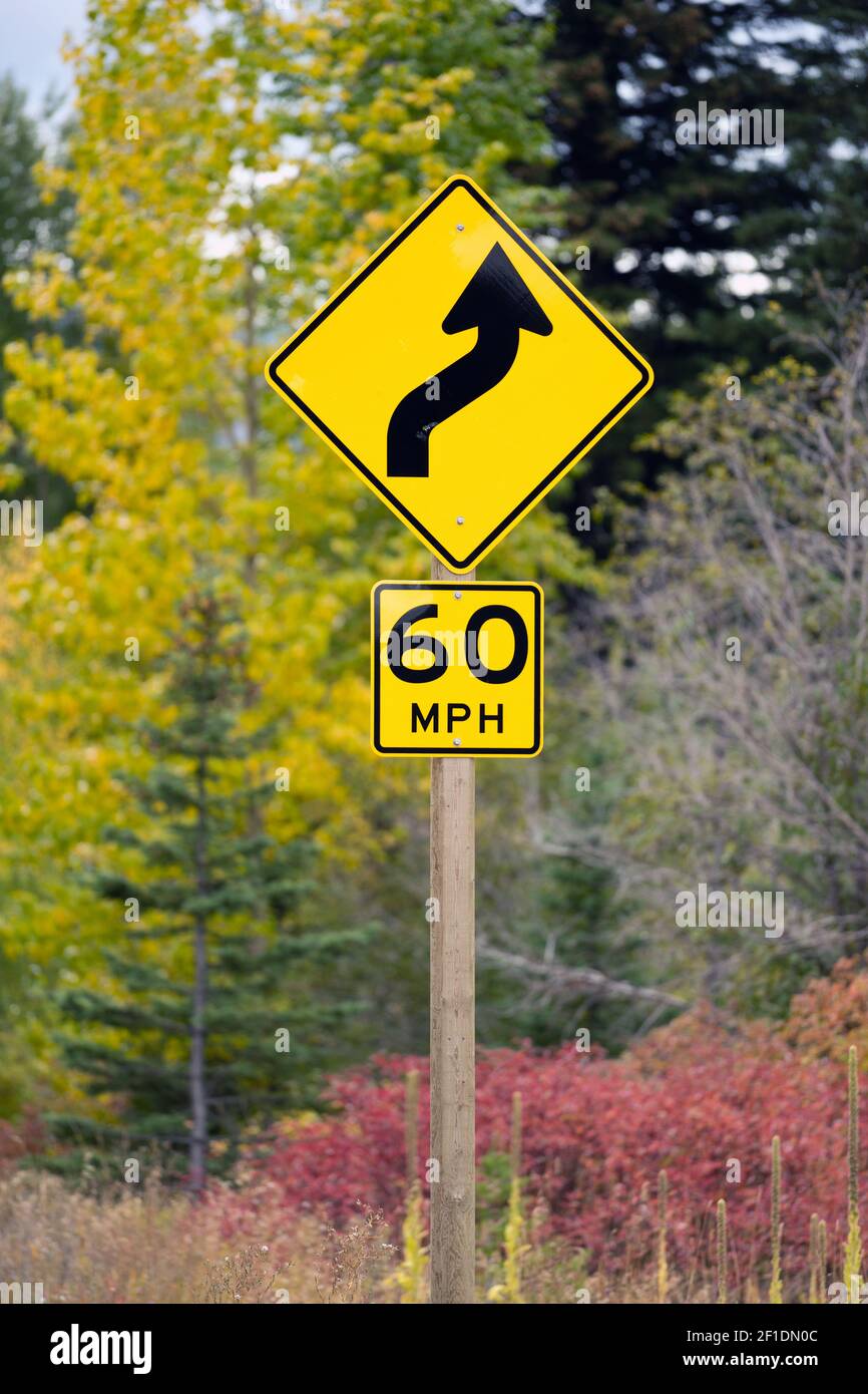 La curva più avanti autostrada segno 60 MPH Foto Stock