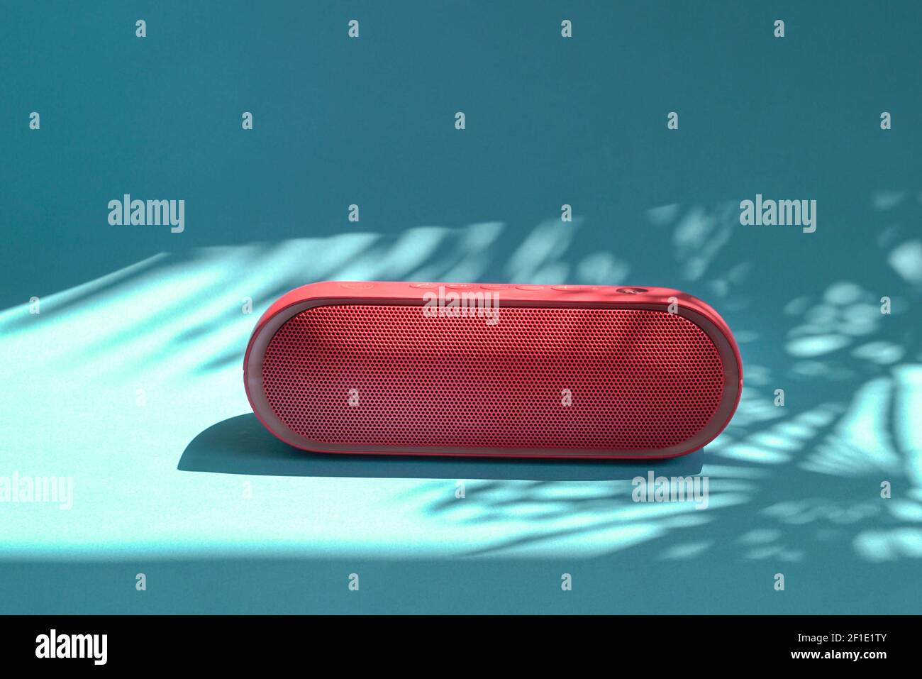 Altoparlante rosso Mini bluetooth isolato su sfondo blu con ombre. Spazio di copia. Foto Stock