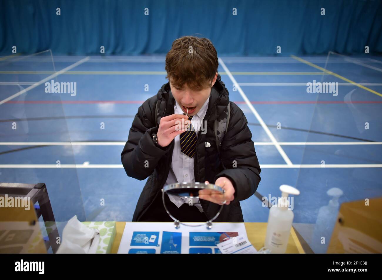 L'allievo dell'anno 11 Ozzy Deane, 15, conduce un boccaglio durante il suo test di flusso laterale mentre arriva alla sala sportiva della Archway School a Stroud, Gloucestershire, mentre gli allievi in Inghilterra ritornano a scuola per la prima volta in due mesi come parte della prima fase di lockdown easing. Data immagine: Lunedì 8 marzo 2021. Foto Stock