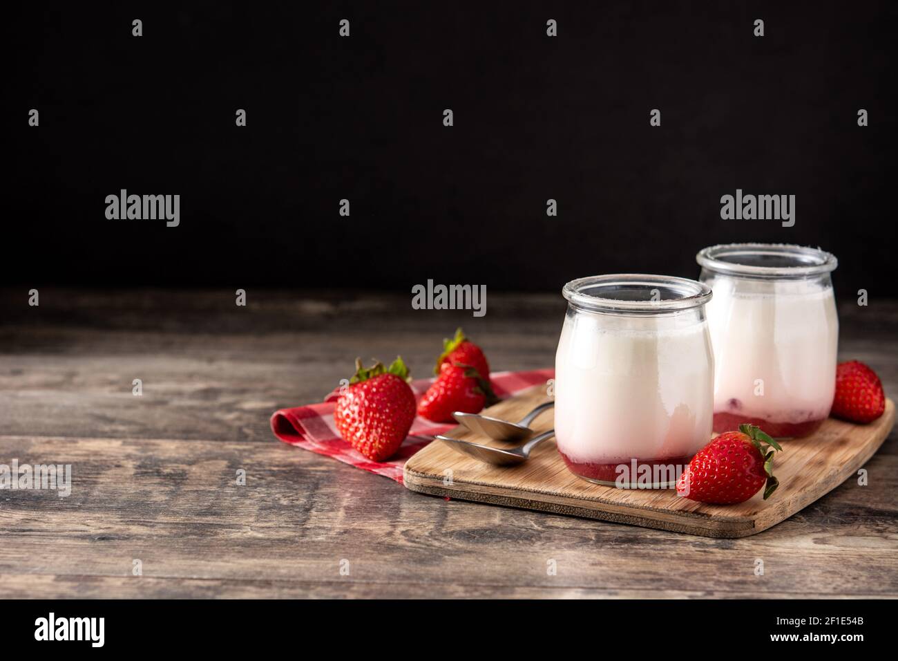 Panna cotta dessert con fragola su tavola di legno e nero sfondo Foto Stock