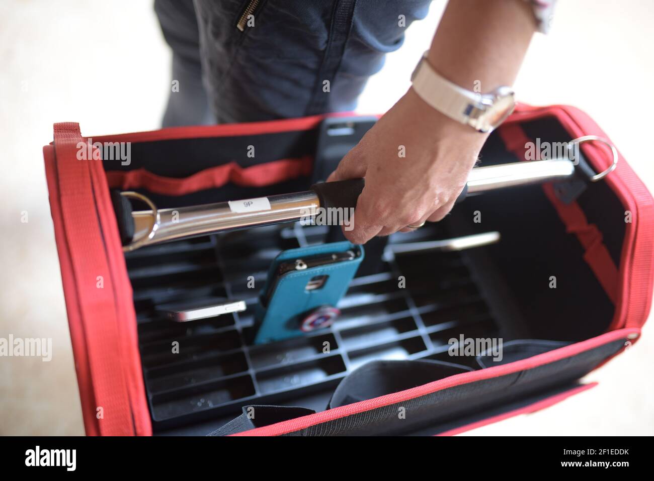 Primo piano di un uomo che tiene una cassetta degli attrezzi rossa Foto Stock