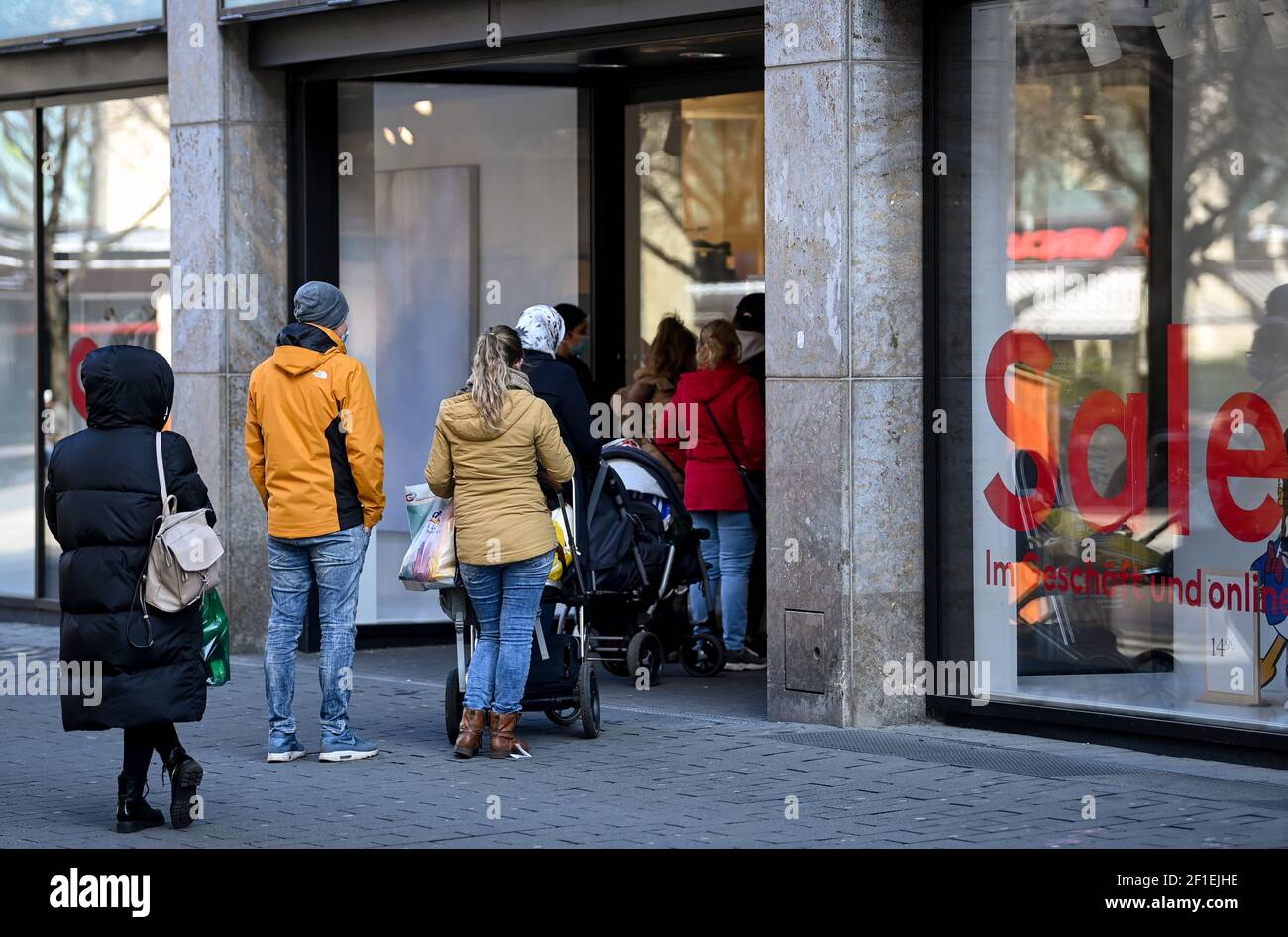 Lipsia, Germania. 8 marzo 2021. I clienti si accodano fuori dall'ingresso  di un negozio H&M a Petersstraße. Dopo un blocco indotto dalla corona di  una settimana, molti rivenditori offrono un nuovo concetto