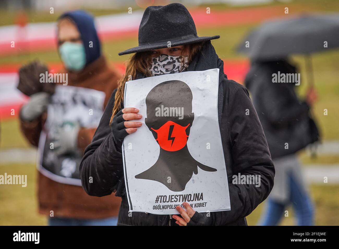 Gdansk, Polonia 7 marzo 2021 il manifestante che tiene un manifesto con un fulmine rosso sulla maschera facciale - il segno del movimento di sciopero femminile polacco è visto a Danzica, Polonia il 7 marzo 2021 il Manifa è un raduno annuale per i diritti delle donne e delle femministe per celebrare la Giornata internazionale della donna, una giornata globale che celebra le conquiste sociali, economiche, culturali e politiche delle donne. I manifestanti chiedono i diritti delle donne, il rispetto e la libera scelta dell’aborto. Credit: Vadim Pacajev/Alamy Live News Foto Stock