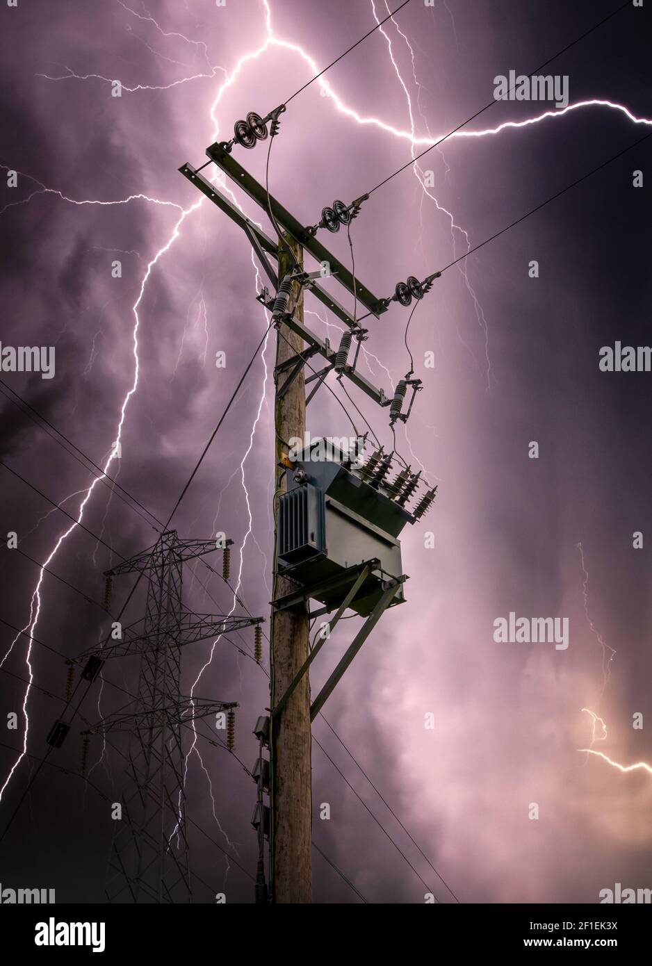 Fulmini luminosi che colpiscono i cavi della torre di traliccio di energia elettrica e il colpo della sottostazione. Scarica di corrente da nuvola a pioggia con trasformatore Foto Stock