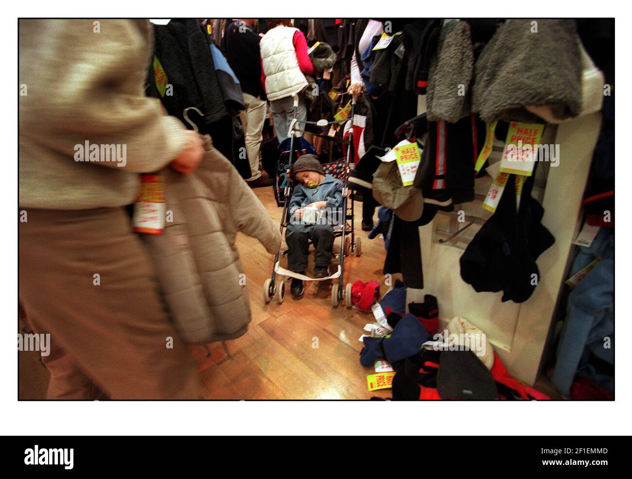 La follia del primo giorno delle vendite di Natale e il suo tutto troppo per questo giovane uomo, nel trafficato centro commerciale Bluewater. Foto Stock