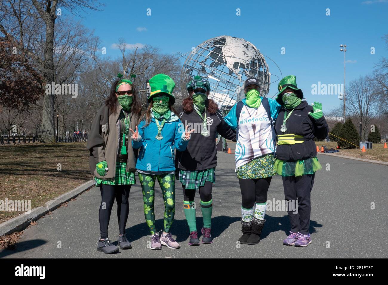 5 donne runner in maschere verdi e costumi per il giorno di San Patrizio al termine della regia di San Patrizio, mezza maratona e gara di runnung 5k. Queens, New York Foto Stock
