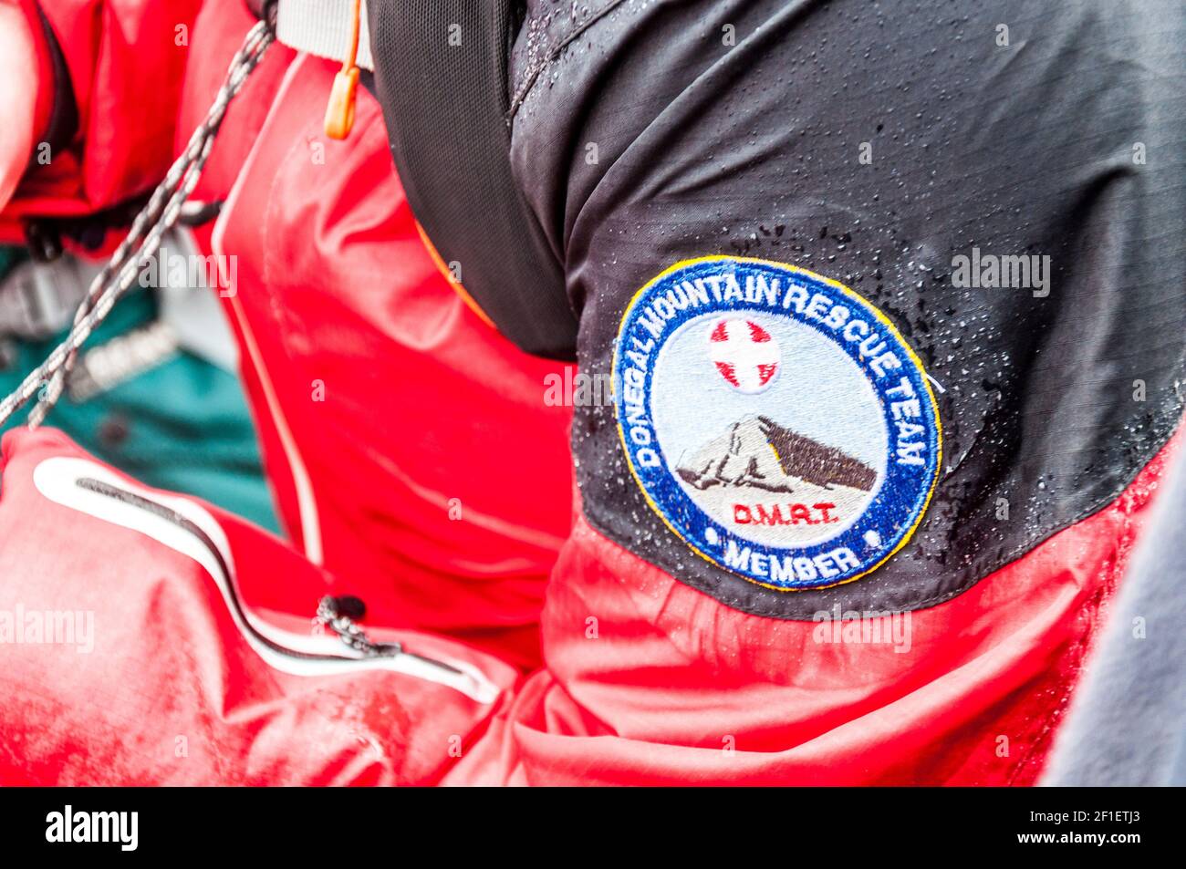 Donegal Mountain Rescue Team membro di una missione. Etichetta con logo sulla manica impermeabile della giacca ad alta visibilità. Foto Stock