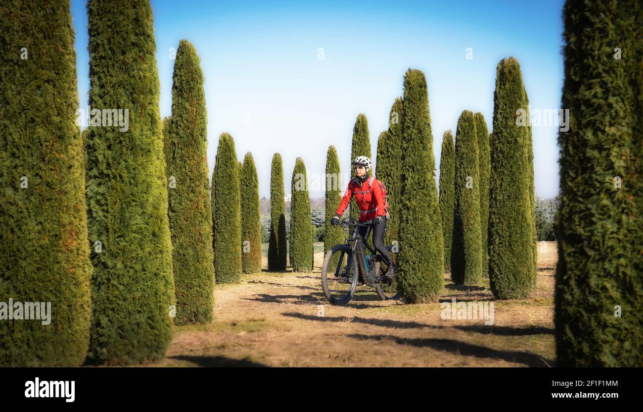 donna anziana che guida la sua mountain bike elettrica fino al Lindau Hut sotto le famose cime di Drusenfluh e tre Torri nella zona di Montafon di Vo Foto Stock