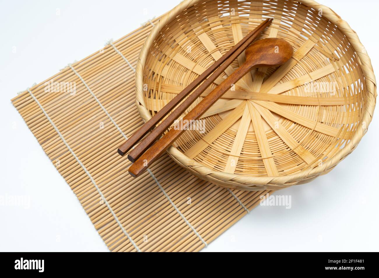 Posate in legno, bastoncini di legno, cesto di bambù, tappetino di bambù Foto Stock