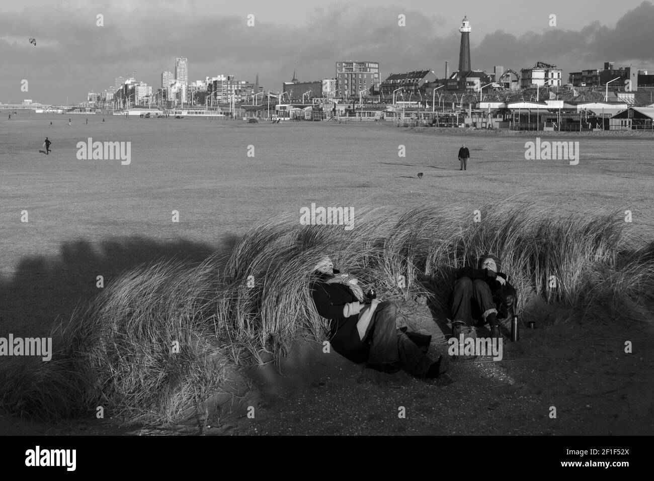 Due donne dormono al sole sulla vegetazione vicino alla spiaggia. Foto Stock