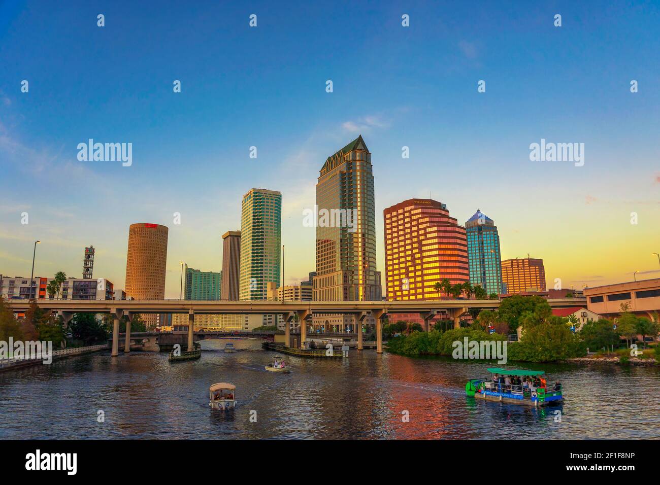 Skyline di Tampa al tramonto con barche turistiche a Hillsborough fiume Foto Stock