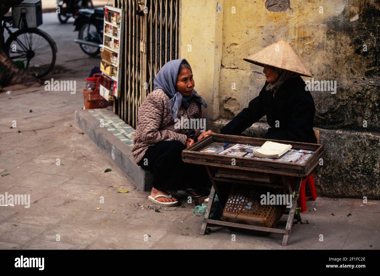 Due venditori di bancarelle di strada che chiacchierano, Hanoi, Vietnam, giugno 1980 Foto Stock