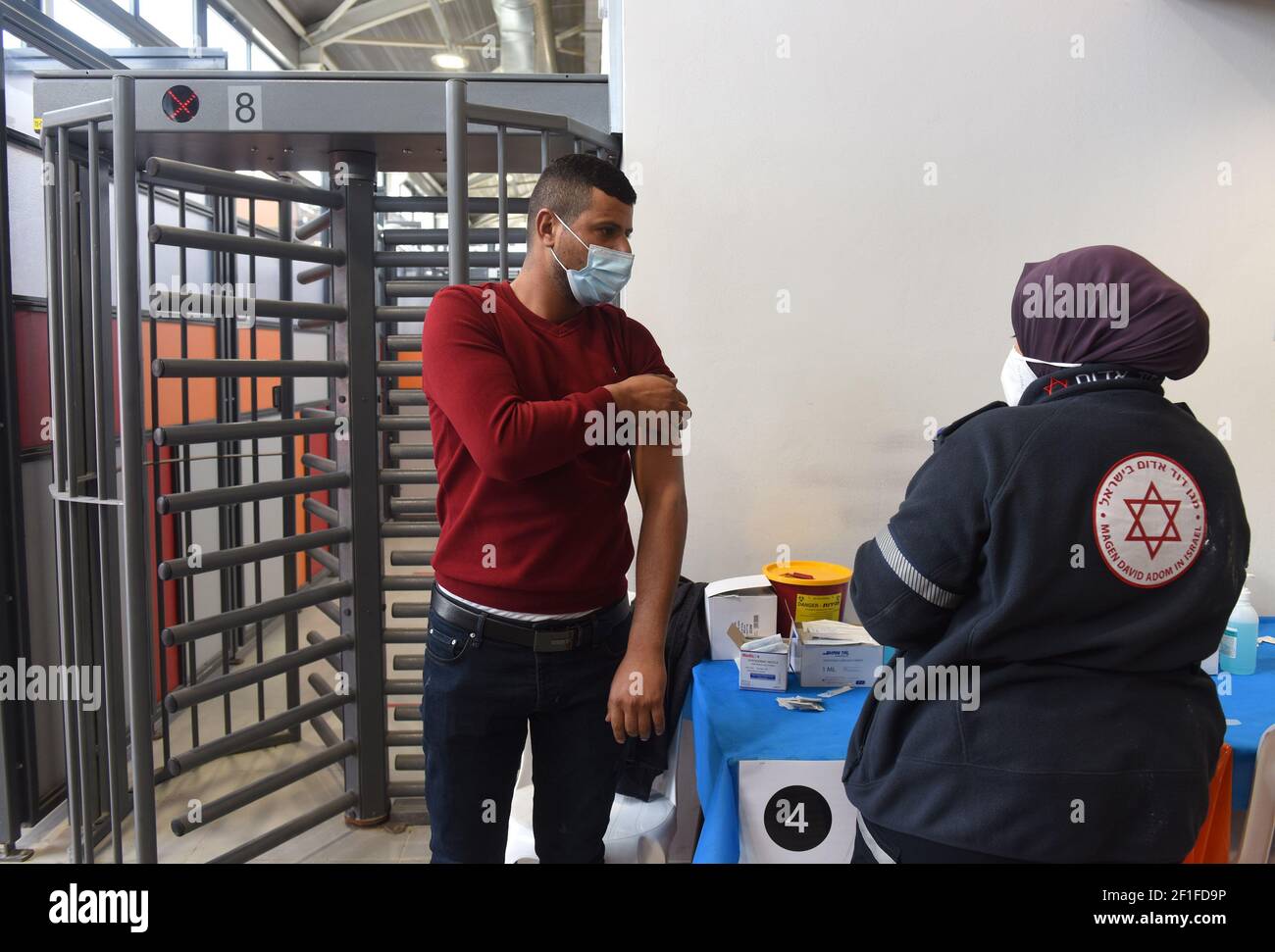 Lamed Hei Checkpoint, Palestina, 8 marzo 2021. Un medico dell'agenzia di emergenza Magen David Adam di Israele inocula un lavoratore palestinese con la prima dose del vaccino moderna COVID-19 al Lamed Hei Checkpoint tra Gush Etzion e Beit Shemesh, lunedì 8 marzo 2021. Israele ha avviato una campagna di due settimane per vaccinare circa 100,000 lavoratori palestinesi della Cisgiordania che detengono permessi per lavorare in Israele e negli insediamenti ebraici. Credit: UPI/Alamy Live News Foto Stock