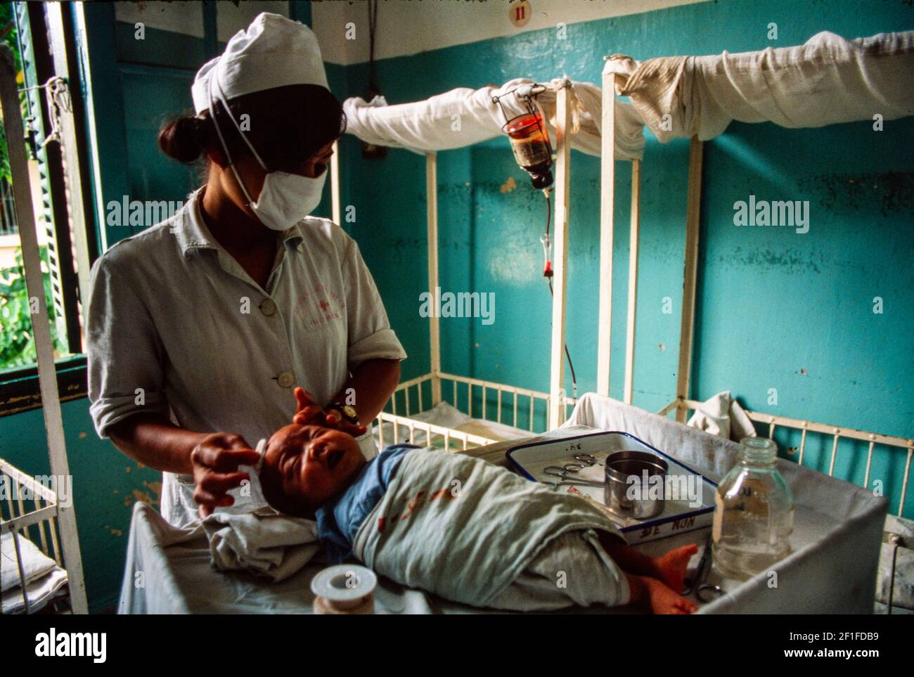 Un neonato è curato da un'ostetrica all'Hanoi Hospital, Hanoi, nel Nord Vietnam, giugno 1980 Foto Stock