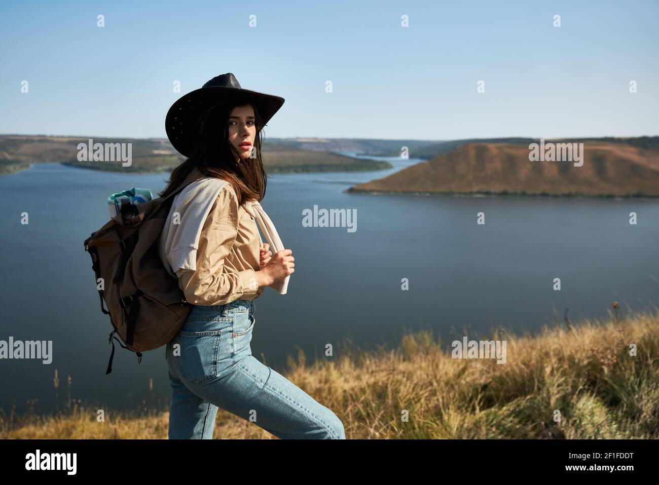 Bella turista femminile in cowboy cappello trekking con zaino al parco  nazionale Podillya Tovtry. Donna felice guardando bella natura verde tra  Dnieste Foto stock - Alamy