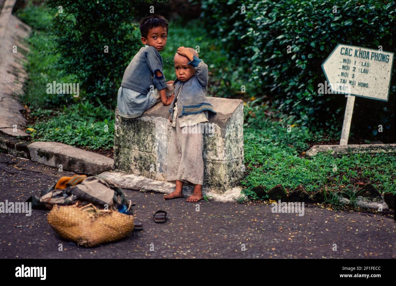 I bambini aspettano la loro madre fuori da un ospedale a ho Chi Minh City, Vietnam, 1980 giugno Foto Stock
