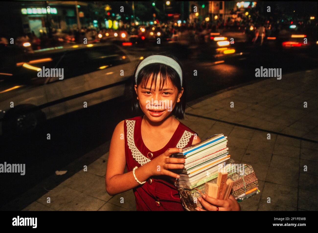 Una giovane ragazza che vende materiali turistici per strada, ho Chi Minh City, Vietnam, giugno 1980 Foto Stock