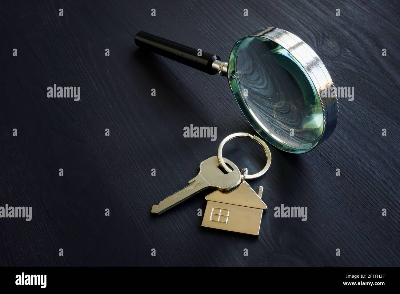 Lente di ingrandimento e chiave per la casa. Concetto di valutazione della proprietà. Foto Stock