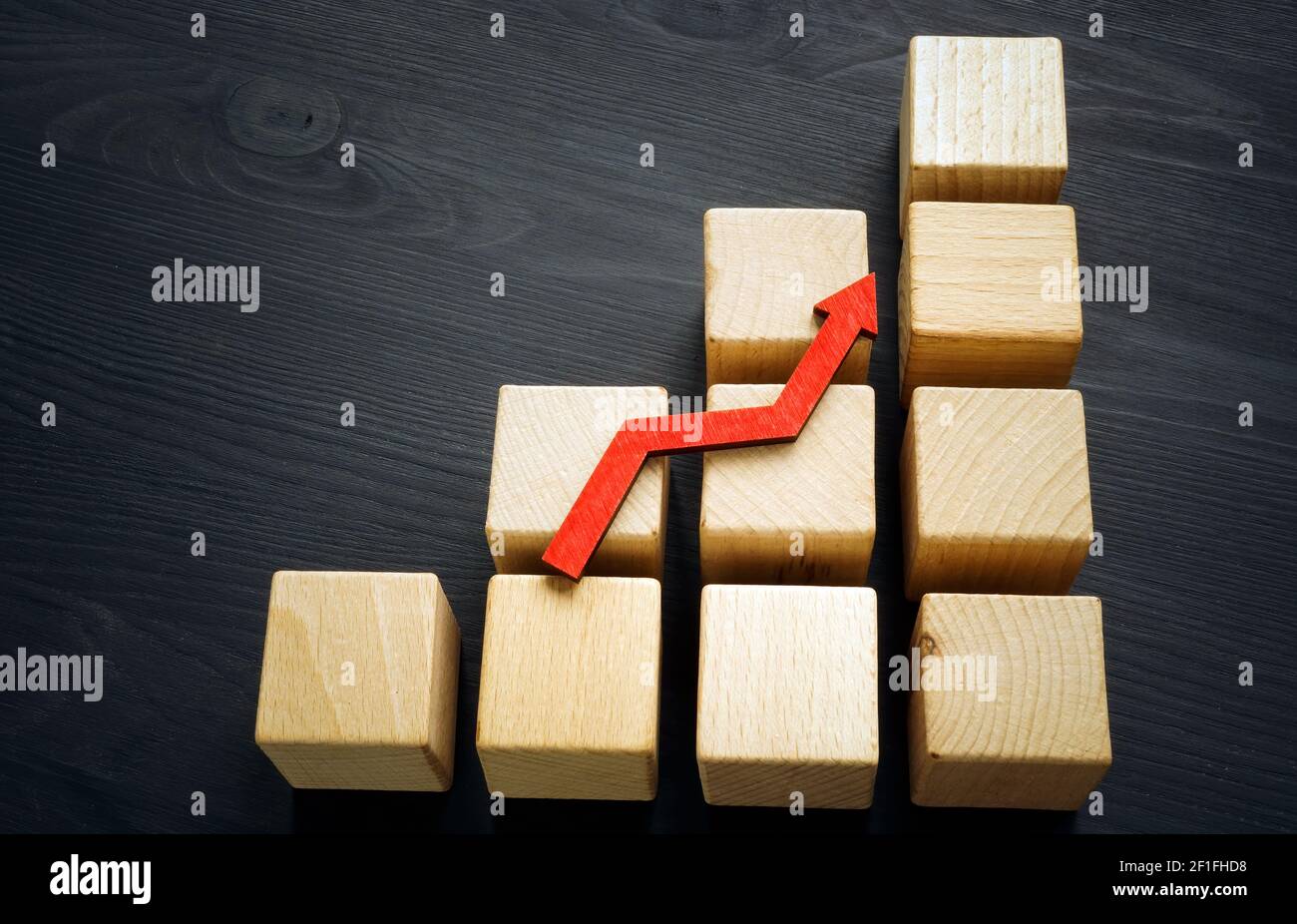Concetto di crescita aziendale e carriera a scala. Cubetti di legno e freccia ascendente. Foto Stock