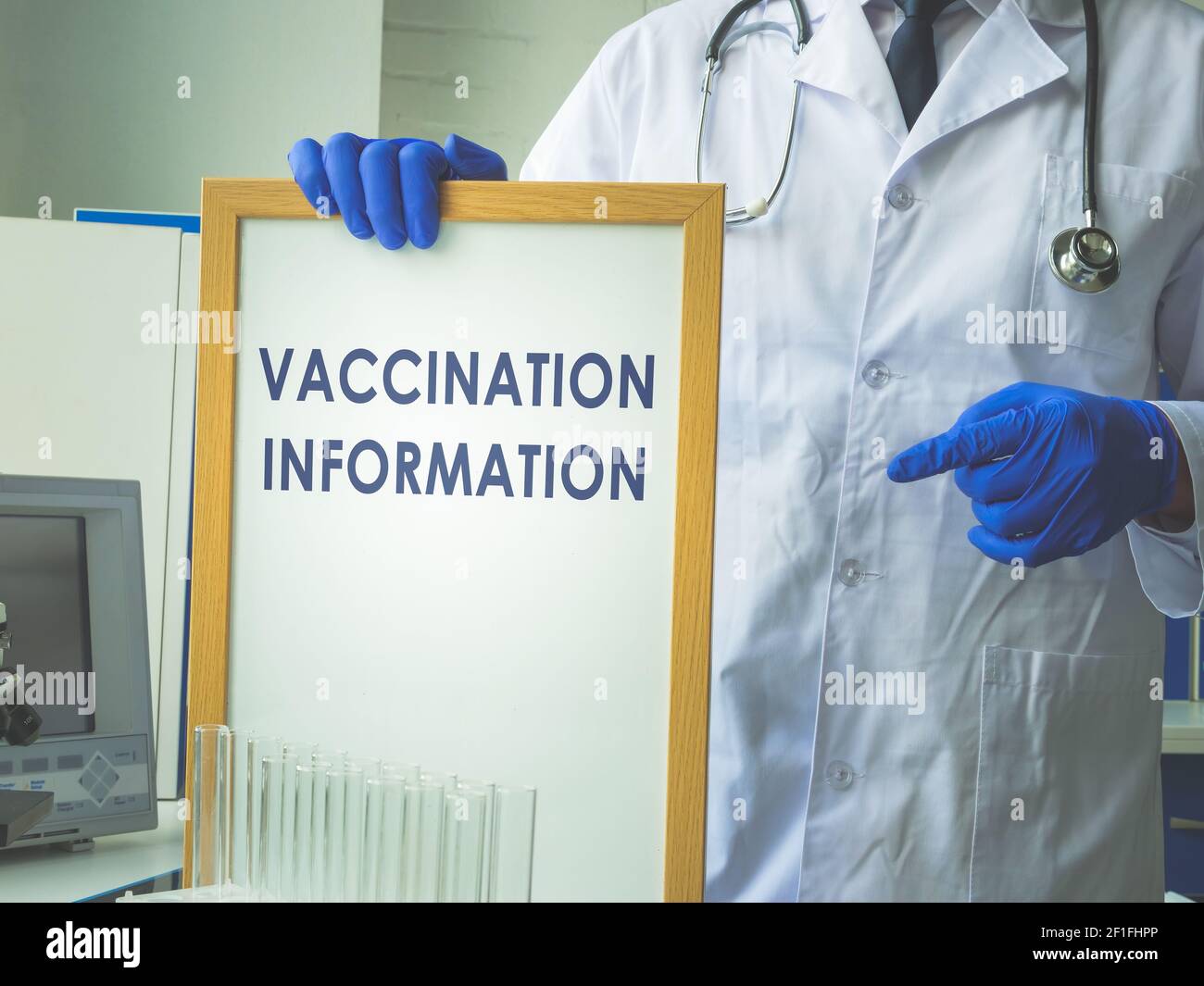 Il cartello con le informazioni sulla vaccinazione sulla lavagna bianca in mano. Foto Stock