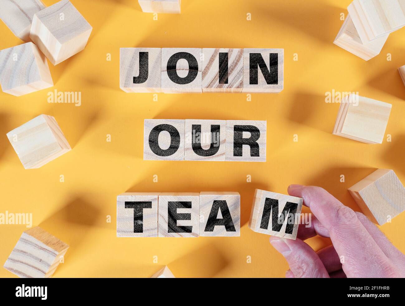 Direttamente sopra la vista del testo UNIRE IL NOSTRO TEAM su legno blocchi su sfondo arancione Foto Stock