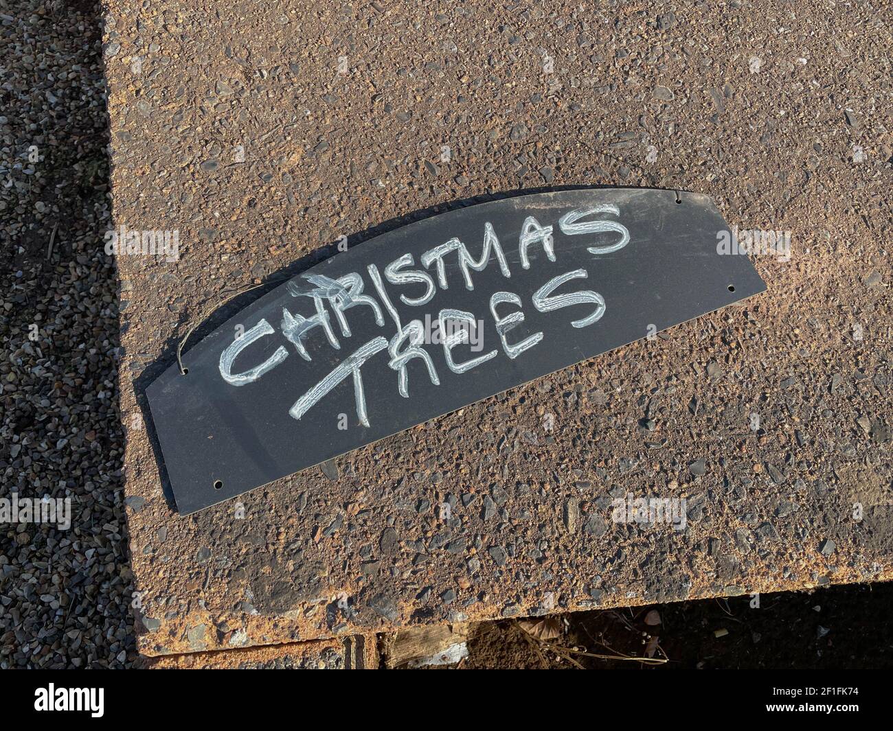 Gli alberi di Natale scritti a mano firmano su uno sfondo di una lastra di pavimentazione di calcestruzzo ad un mercato agricolo a Copplestone in Devon rurale, Inghilterra, Regno Unito Foto Stock