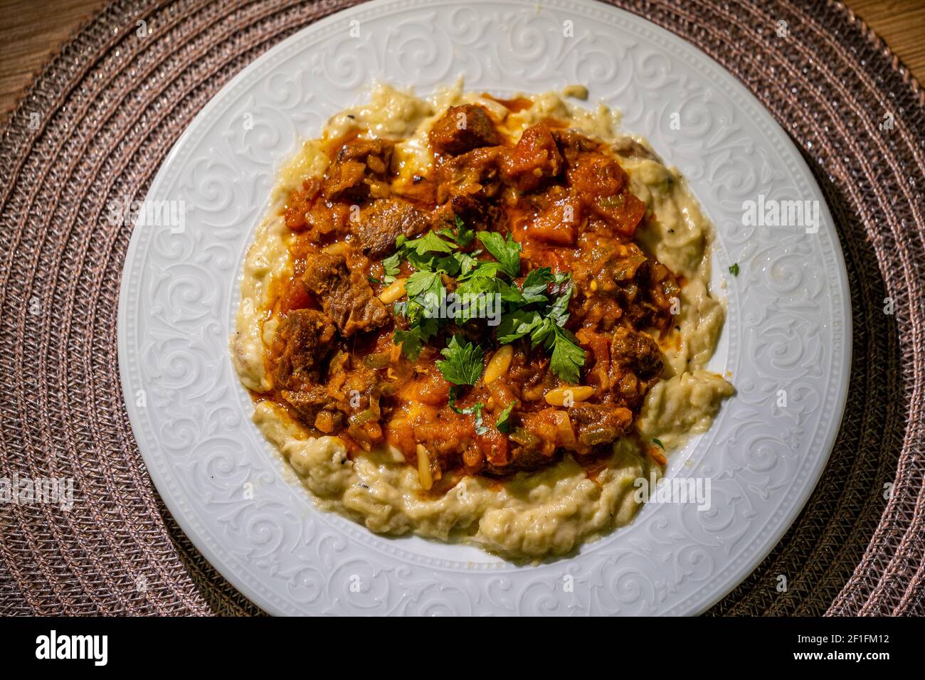 Purea di melanzane con yogurt servito con carne macinata stagionata Foto Stock