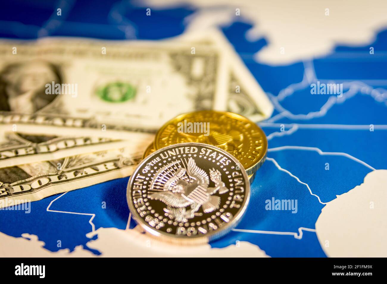 Il presidente Trump monete e banconote in dollari sulla mappa degli Stati Uniti Foto Stock