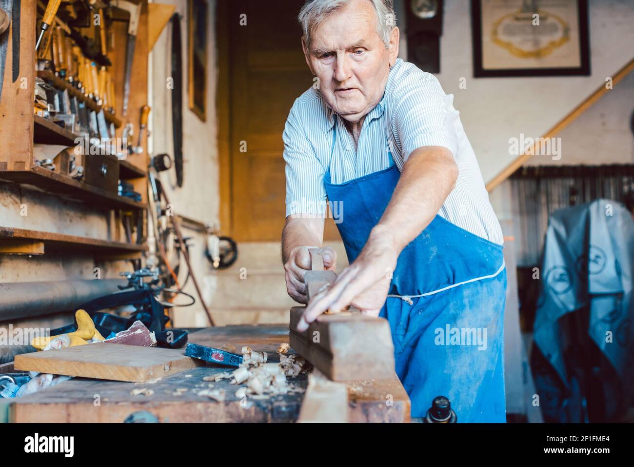 Esperto falegname principale che lavora con la pialla su legno Foto Stock