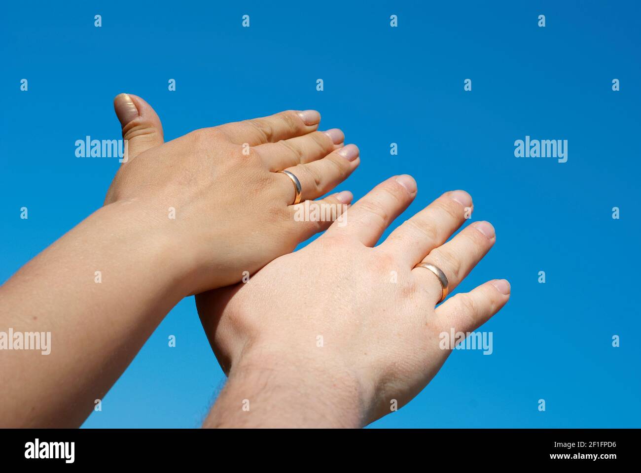 due mani contro il cielo blu Foto Stock