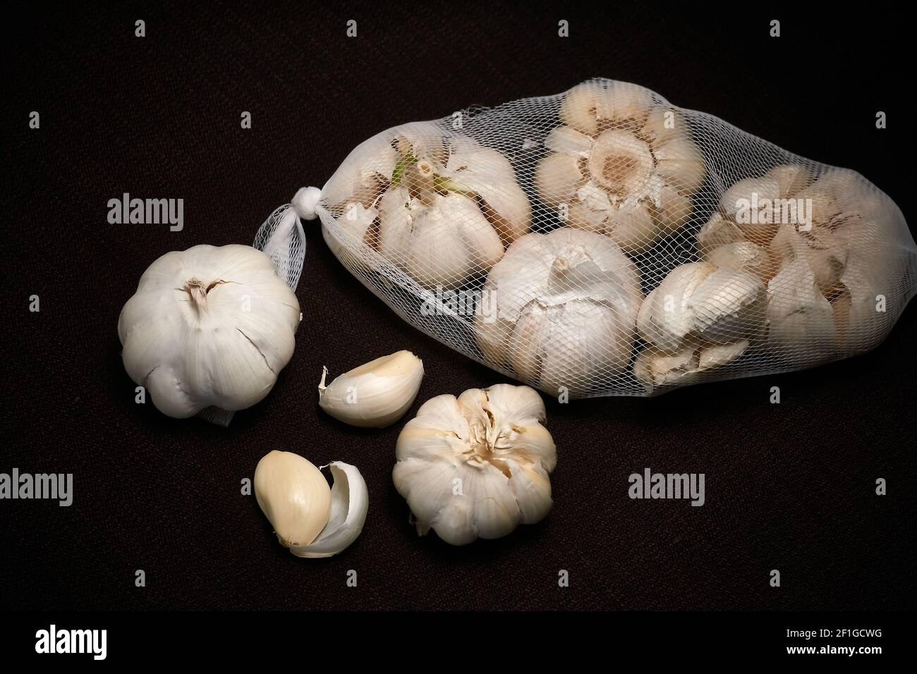 Aglio, testa d'aglio su fondo scuro con leggera sfocatura, mesh d'aglio Foto Stock