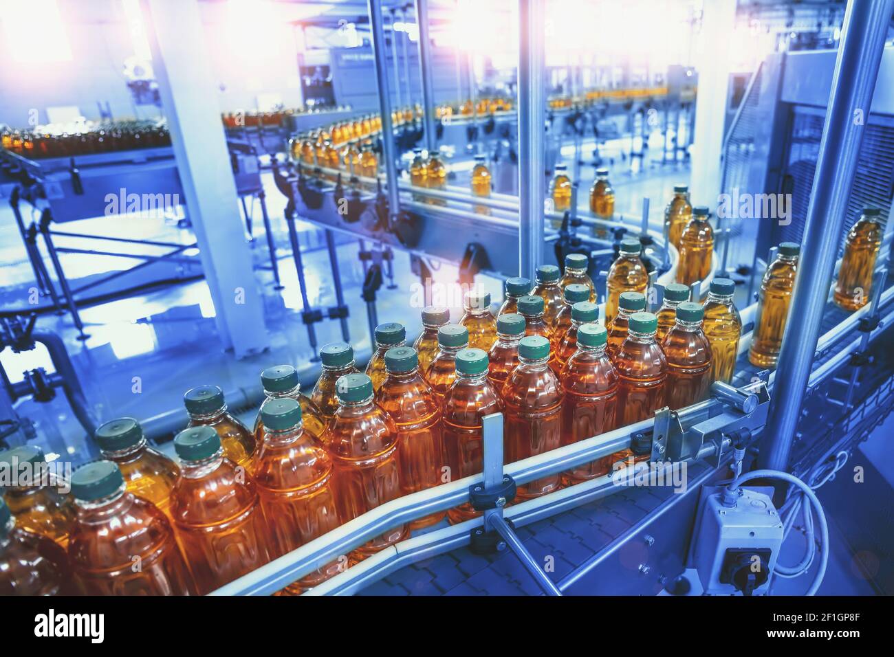 Linea di produzione, nastro trasportatore, succo d'arancia in bottiglie in fabbrica di bevande. Foto Stock