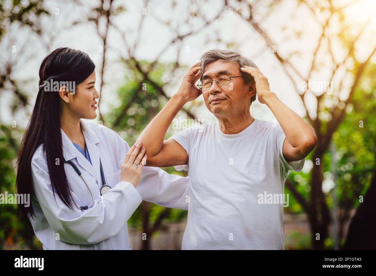 Gentile Dottore avendo cura di senior l uomo nel giardino dell'ospedale. Medico e sanitario Servizio medico concetto. Foto Stock
