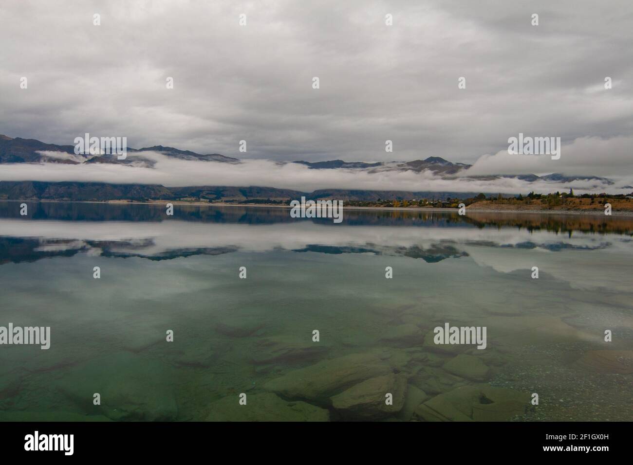 Lago Hawea vicino a Wanaka, Isola del Sud della Nuova Zelanda. Melancolico nuvoloso e nebbia paesaggio mattutino. Foto Stock