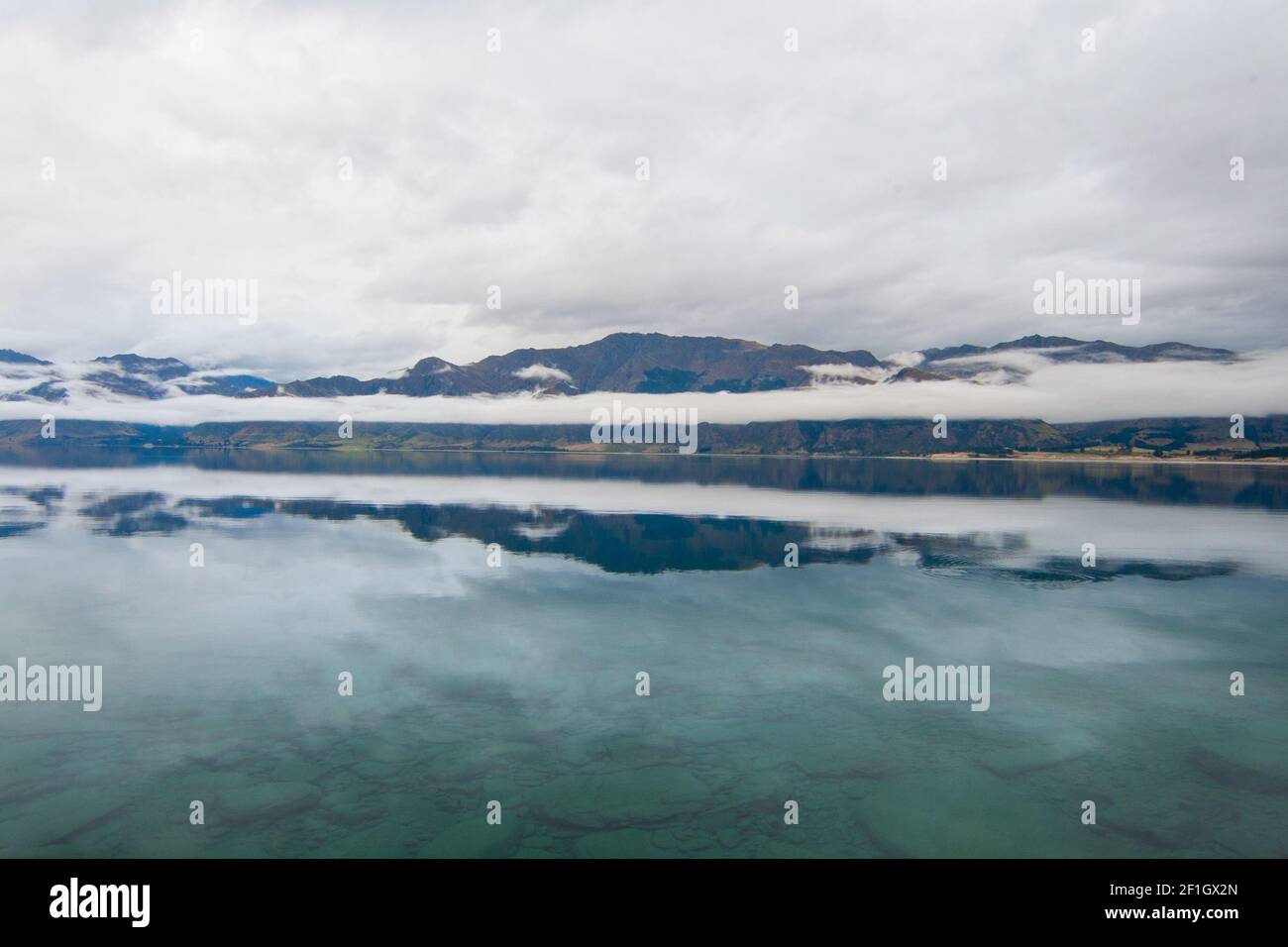 Lago Hawea vicino a Wanaka, Isola del Sud della Nuova Zelanda. Melancolico nuvoloso e nebbia paesaggio mattutino. Foto Stock