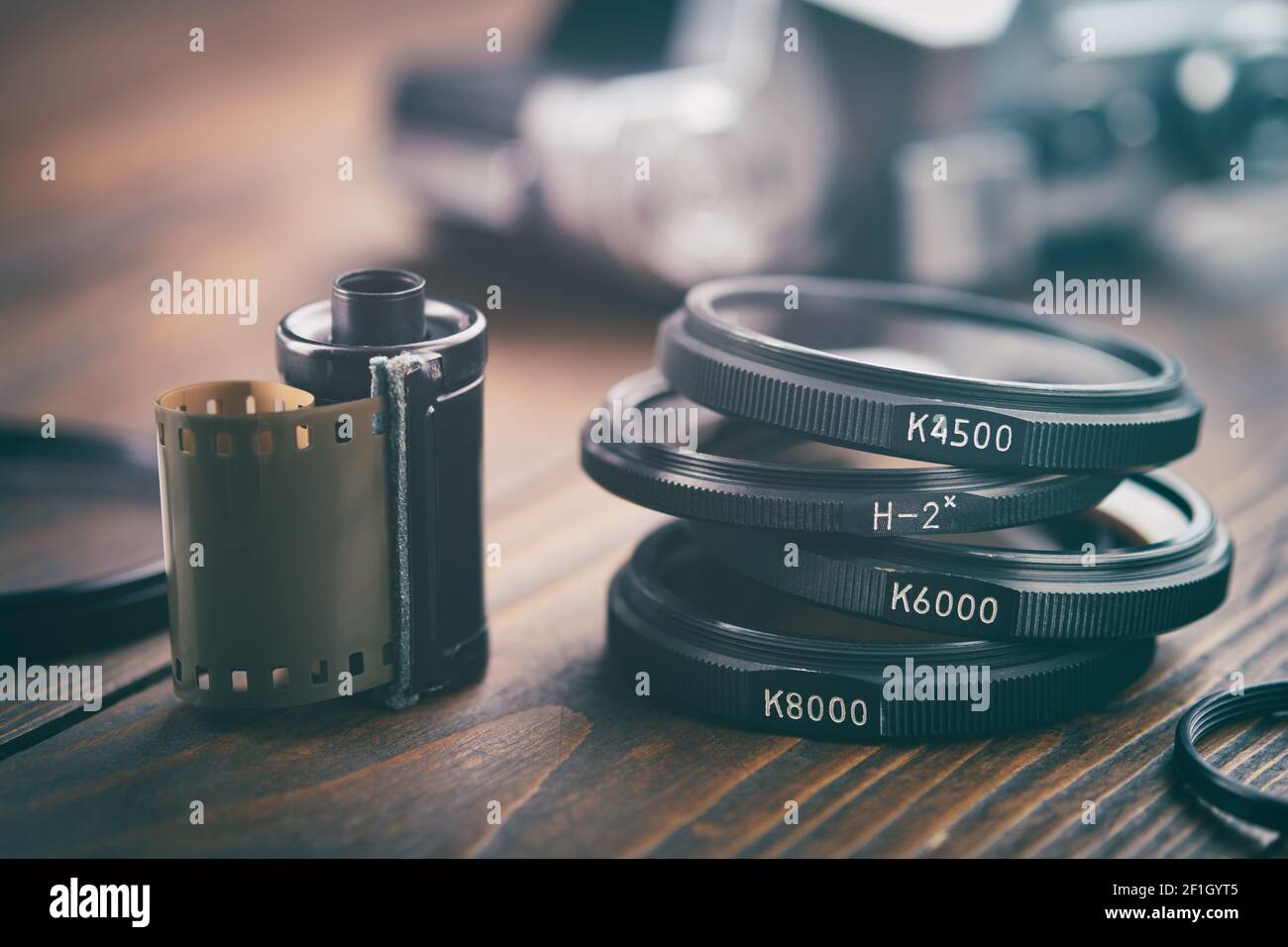 Vecchia cassetta per pellicole fotografiche, filtri fotografici, fotocamera vintage sullo sfondo, messa a fuoco selettiva. Foto Stock