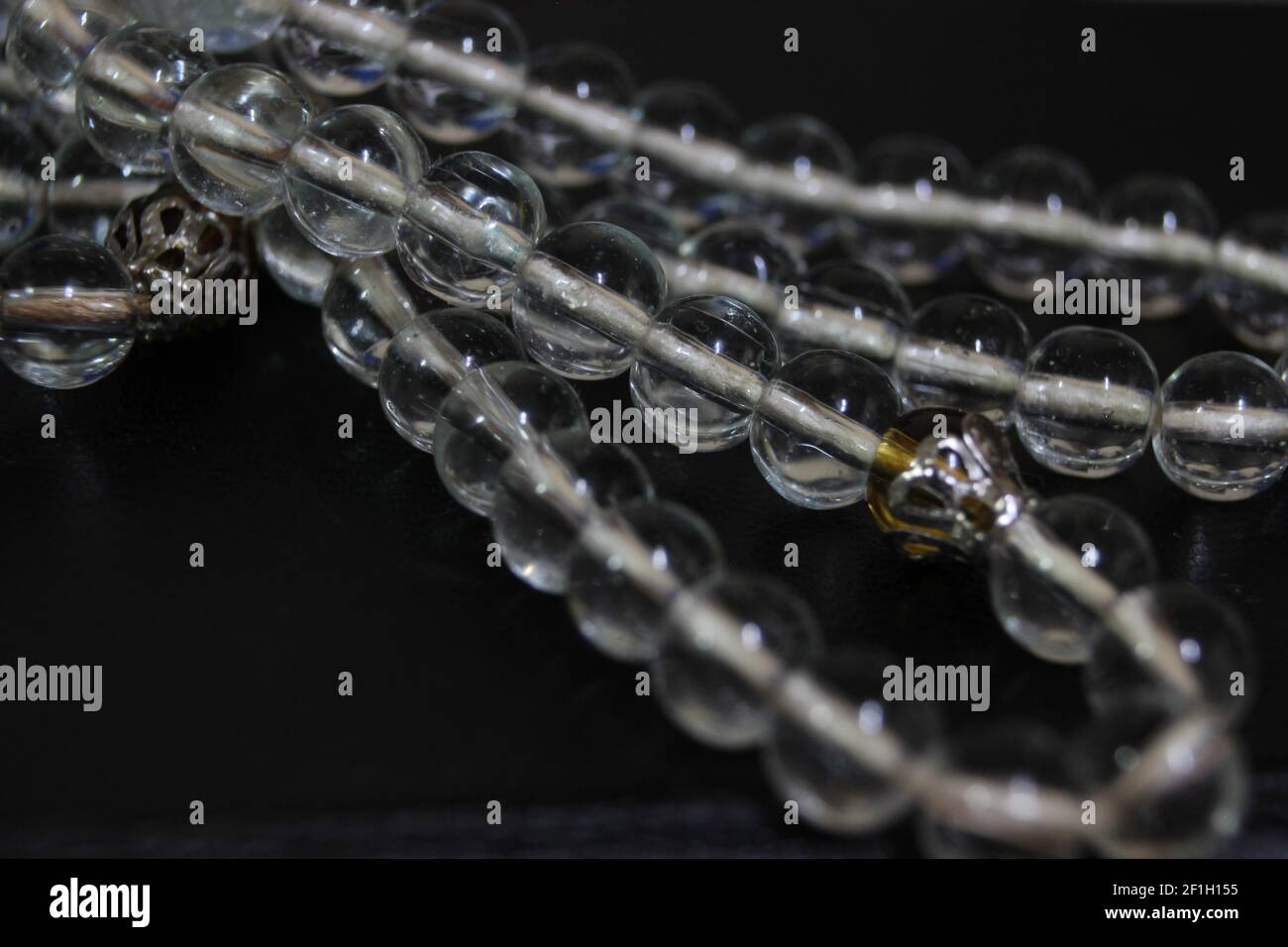 Un macro shot di perle di preghiera lucenti di vetro o rosario; concetto di religione di Ramadan o Eid per i musulmani Foto Stock