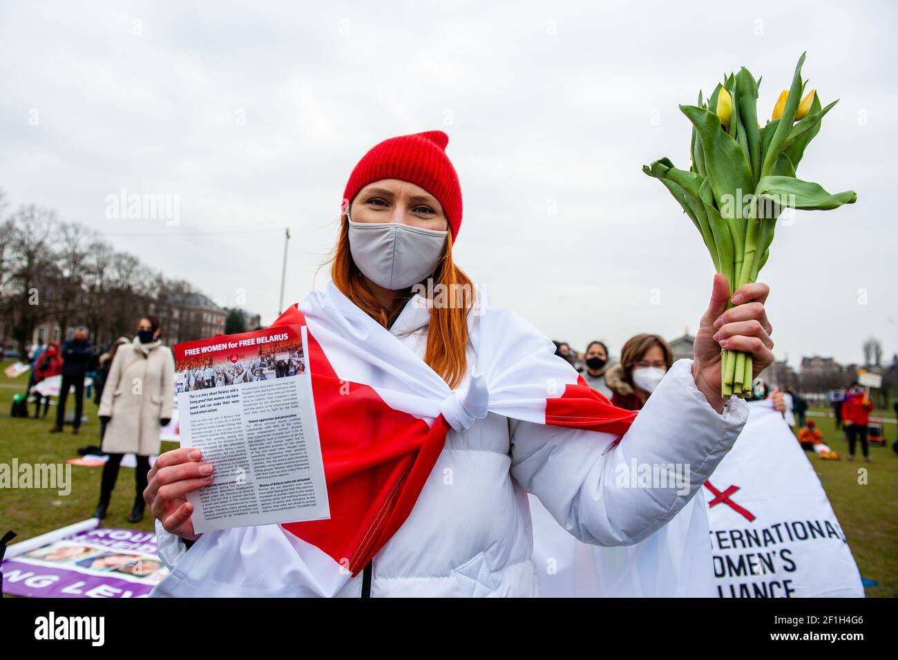 Durante la manifestazione, un manifestante tiene un bouquet di tulipani a sostegno delle donne bielorusse. L'evento è stato organizzato da '8 maartcomité', un gruppo di iniziative indipendenti composto da donne attive di diverse organizzazioni e background, impegnate nell'organizzazione della celebrazione militante della Giornata internazionale della donna ad Amsterdam. Al Museumplein, centinaia di persone si sono riunite per lottare per la parità di diritti delle donne in tutto il mondo. Foto Stock
