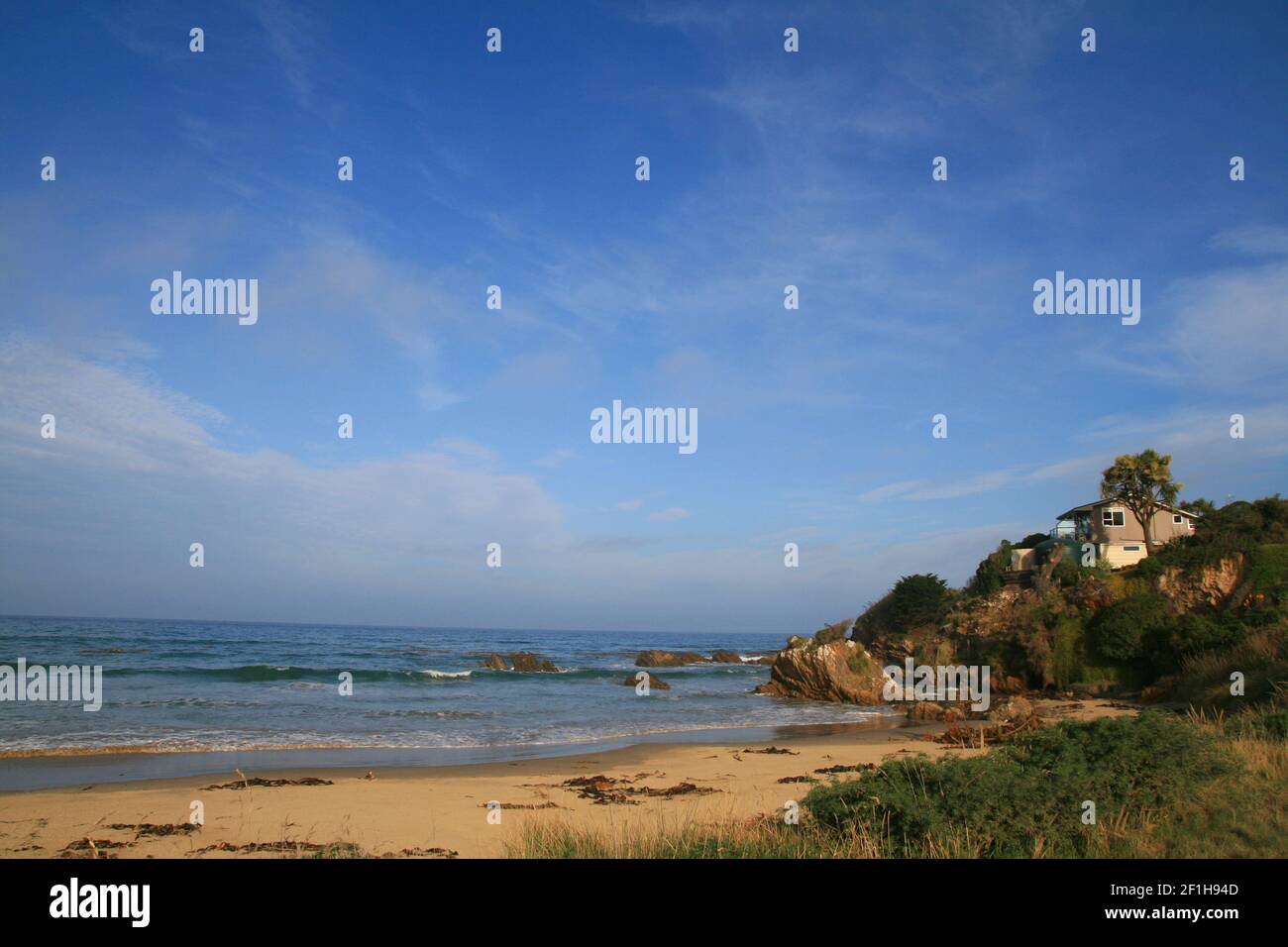 Wild South Ocean Beach con spiaggia casa sulle rocce, Nugget Lodge vicino a Nugget Point, Southland, Nuova Zelanda Foto Stock