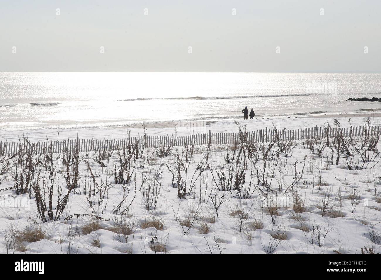 11 febbraio 2021 : due figure lontane su Long Beach coperte di neve che camminano l'una verso l'altra. Foto Stock