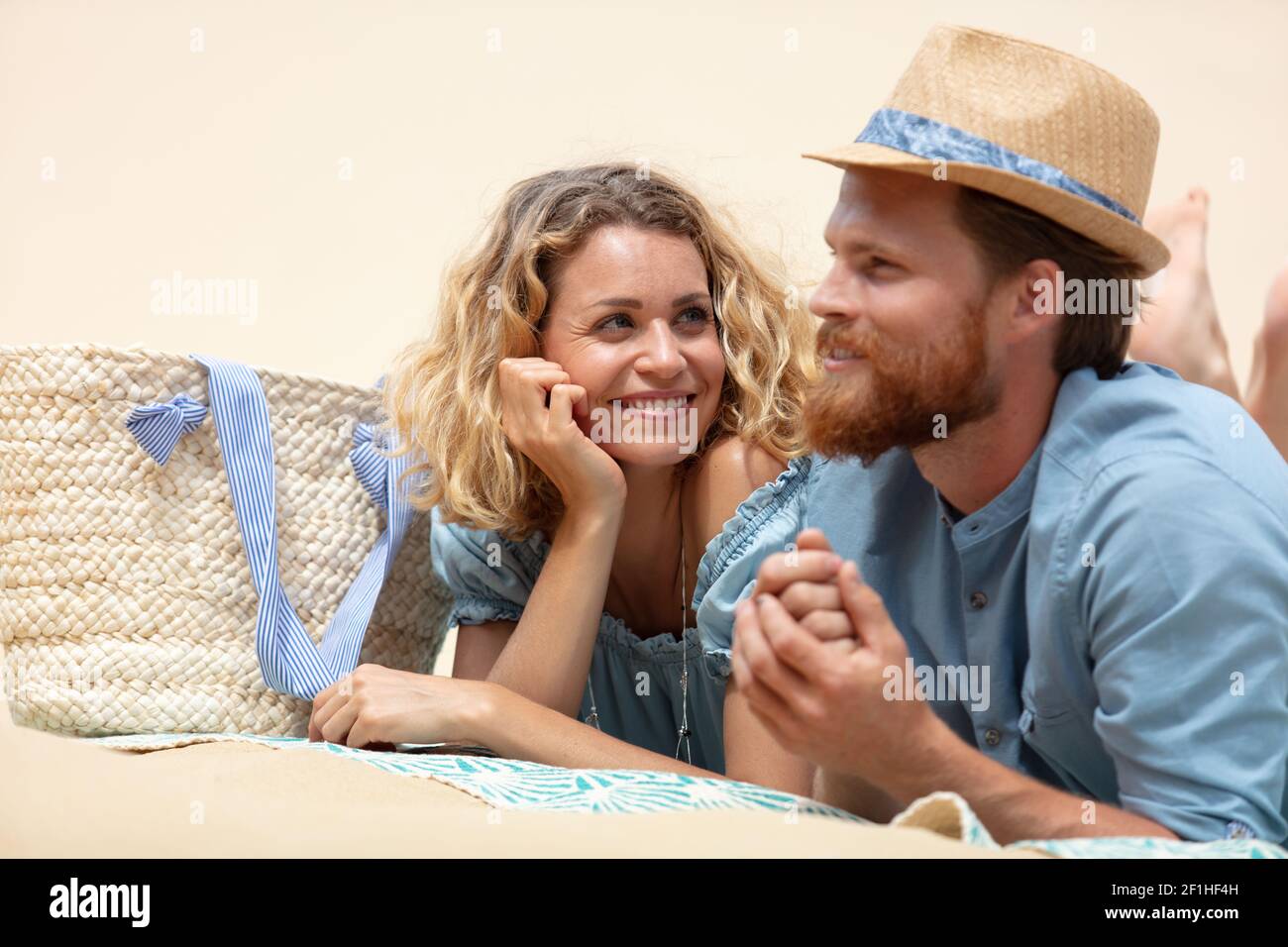 coppia adagiata sulla spiaggia di sabbia bianca Foto Stock