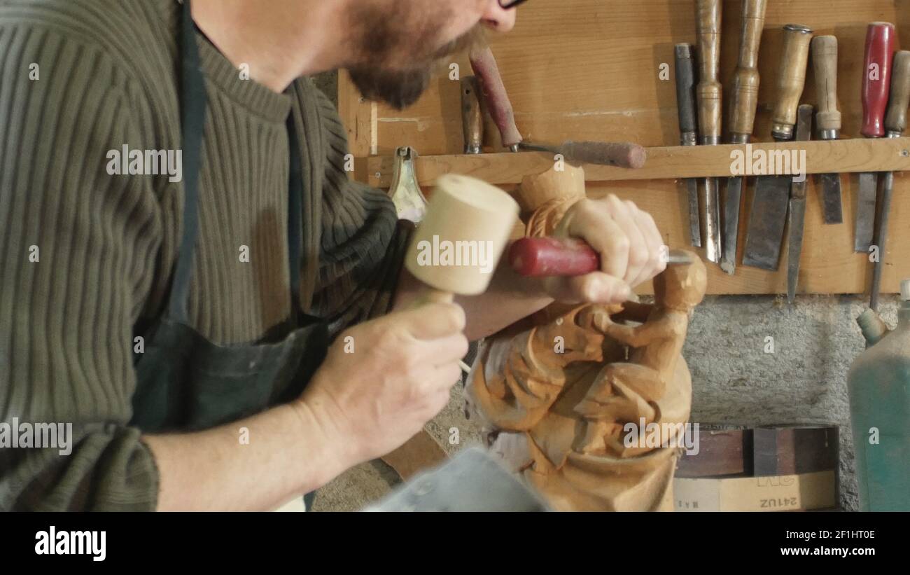 Campo medio su scultore che carve una madonna, in legno Foto Stock
