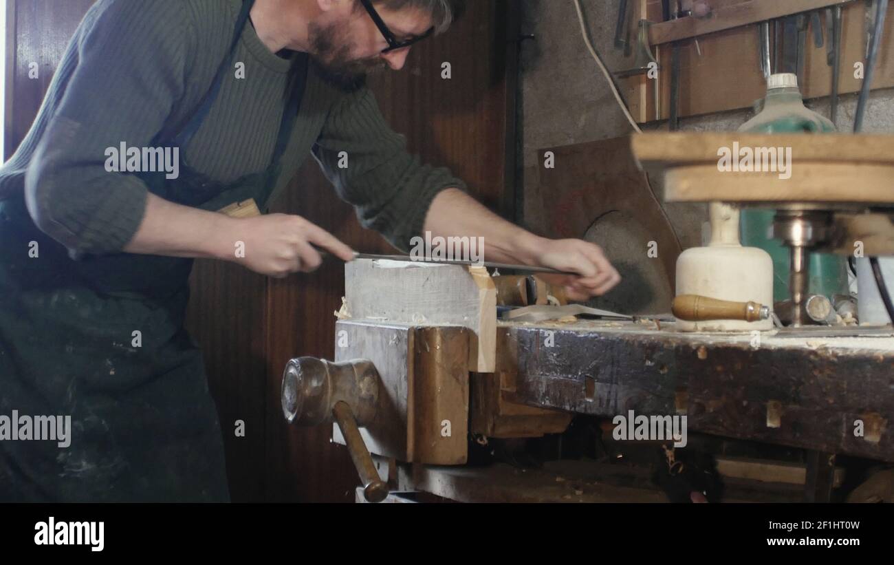 Campo medio di una lima di falegname un pezzo di legno con un file carpenter Foto Stock