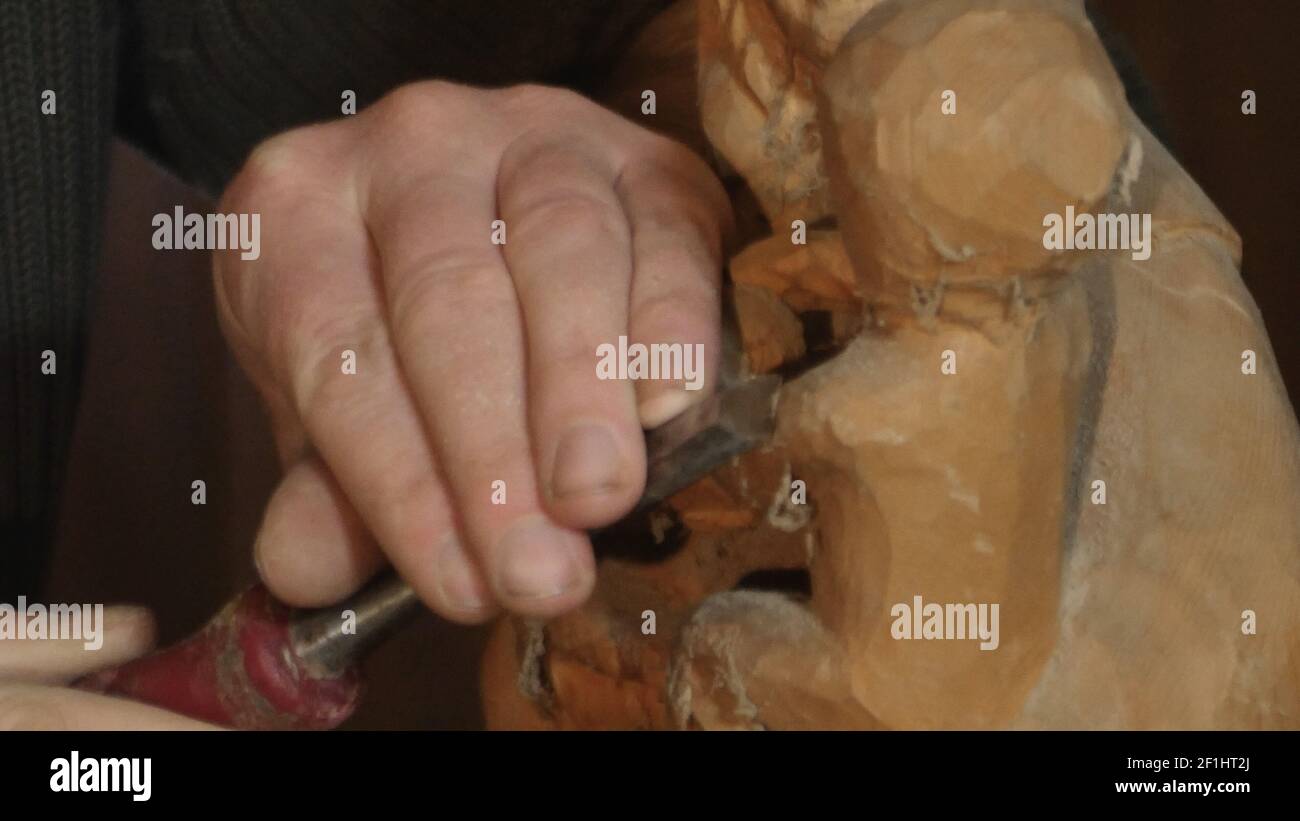 Primo piano scultore che intaglia una madonna, in legno Foto Stock