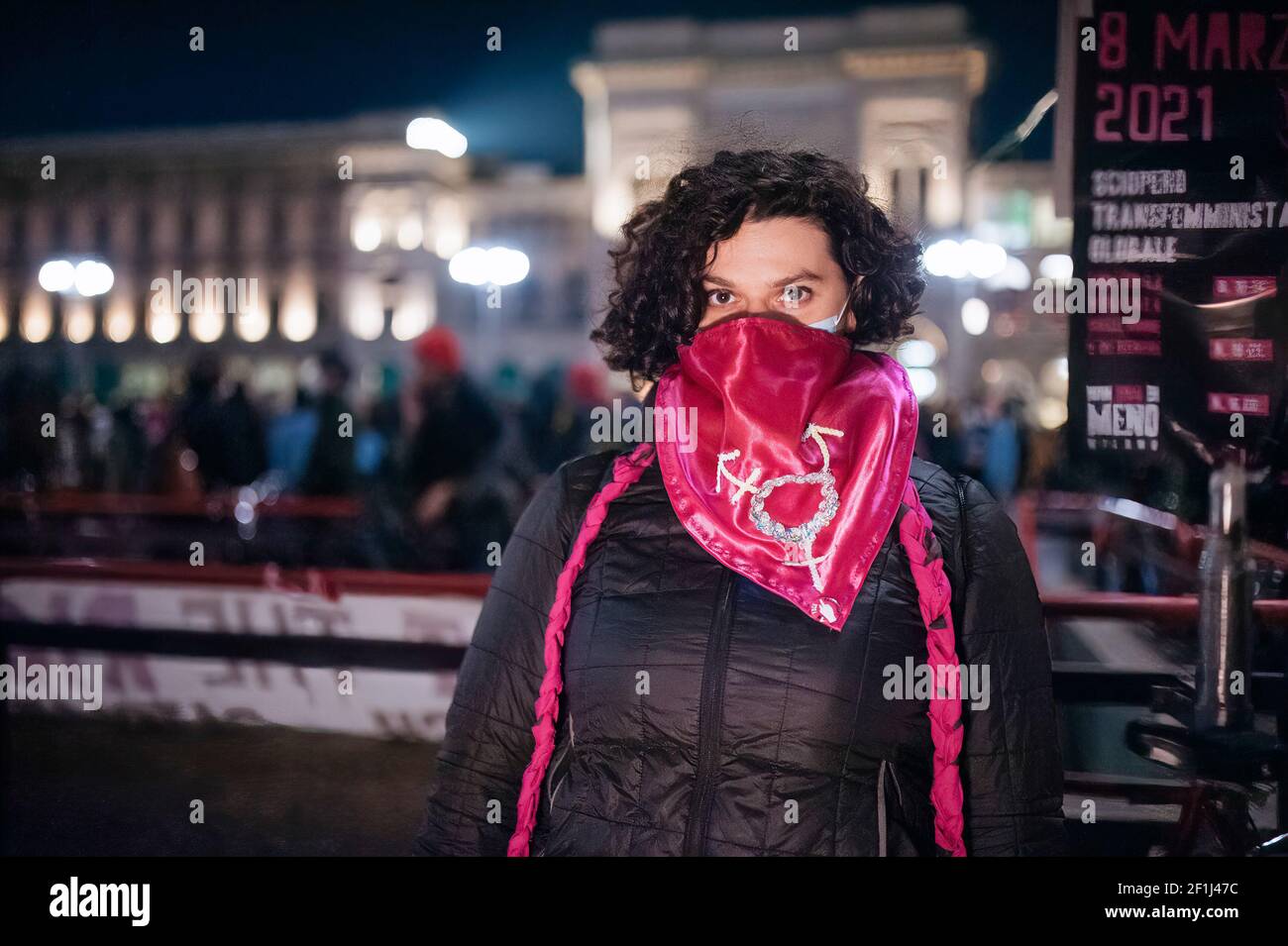 Una donna si pone con una sciarpa rosa, simbolo del femminismo durante la  marcia. La Giornata Internazionale delle Donne è stata celebrata in Piazza  Duomo, a Milano, dove il movimento femminista non