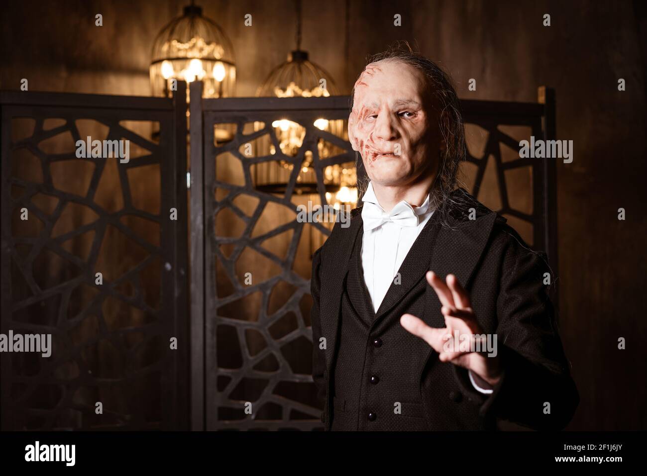un uomo brutto in un cappotto tiene fuori la sua mano - cosplay per il musical il Fantasma dell'Opera Foto Stock