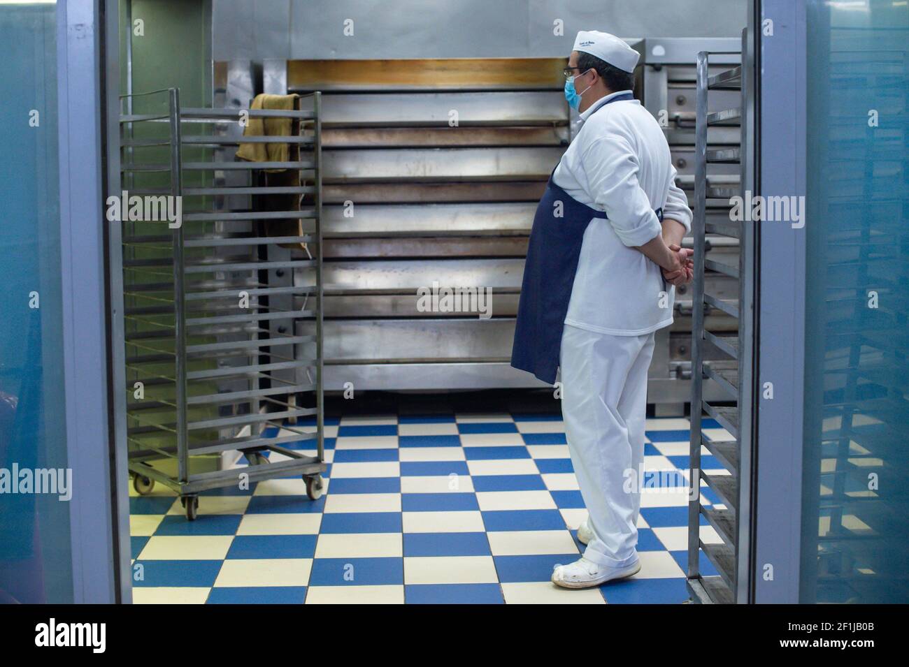 Lisbona, Portogallo. 18 Feb 2021. Baker, Paul Martins attende per i dolci da cuocere. Da una vecchia e segreta ricetta del Mosteiro dos JerÃ³nimos, i famosi Pastéis de Belém sono stati prodotti dal 1837 nella stessa posizione, nel quartiere di Lisbona di Belém, a mano e solo con metodi tradizionali. La panetteria dispone anche di una caffetteria per gustare i dolci all'interno, ma a causa delle restrizioni del coronavirus l'azienda sta vendendo solo in un servizio da asporto e la produzione è stata drasticamente ridotta. Quando, prima della situazione pandemica stavano cuocendo fra 20000 e 25000 unità p Foto Stock