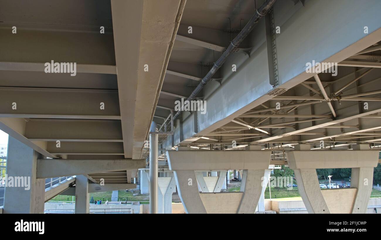 Bianco enorme, impressionante ponte di cavalcavia. Vista dal basso: Montanti di supporto della costruzione, che si espandono a trapezio verso l'alto e rinforzi e Foto Stock