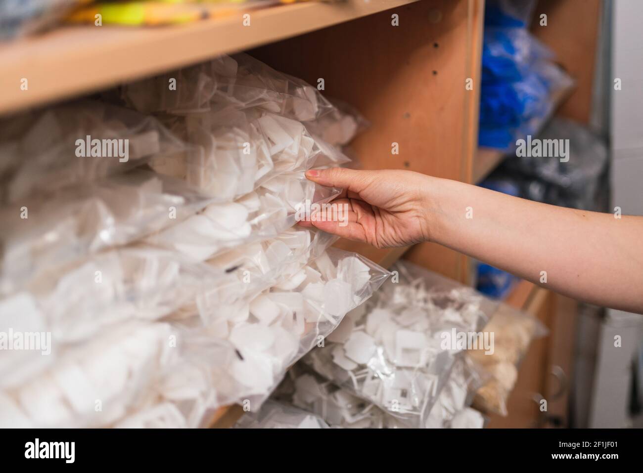 Una mano femminile che tiene scorte di inventario su un magazzino Foto Stock